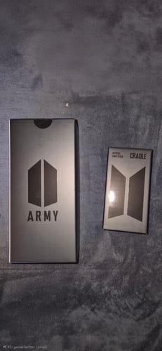 Customer's packaging for the BTS Official Light Stick Ver.4 and the separate Cradle box resting on a grey surface.