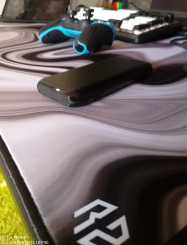 Kunde zeigt das RZ Mousepad Sakura Black auf seinem Schreibtisch mit Gaming-Zubehör.