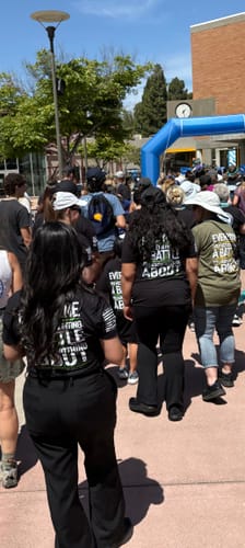 A team of reviewers at an outdoor walk, seen from behind wearing the brand's black and green shirts.