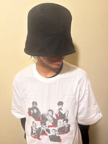 Reviewer wearing the black STUD DROP OVERFIT BUCKET HAT, showing how its deep fit covers their eyes.