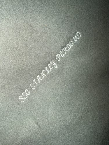 Close-up of the dark fleece backing on a customer's Premium T-Shirt Quilt with custom white text.