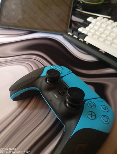 Rezensent zeigt die schwarzen RZ Controller Grips auf einem hellblauen PS5-Controller.