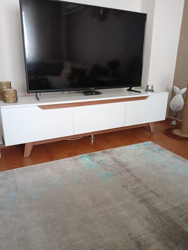 Müşterinin oturma odasında duran, üzerinde televizyon olan beyaz ve ceviz rengi Rani D1 TV ünitesi.