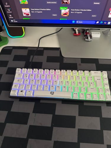 Ein Kunde zeigt die weiße Gaming-Tastatur RZ 65 HE mit leuchtender RGB-Beleuchtung auf einem Schreibtisch.