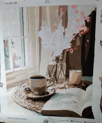 Ein Rezensent zeigt das unvollendete Gemälde des "Malen nach Zahlen - Interieur in Beige"-Sets.