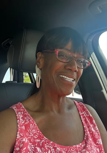 A happy customer smiling in a car, showing off their new Pop On Veneers.