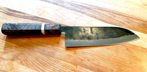 Customer's Hatsukokoro Kurogane Santoku showing its rustic finish and birch handle on a wooden cutting board.