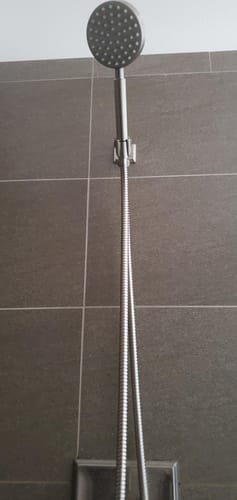 Customer's 1-Spray Handheld Shower Head Set with a long hose installed on a dark tiled shower wall.