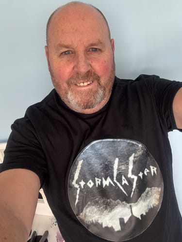 Customer wearing a black unisex t-shirt with a custom graphic for their band 'Stormcaster'.