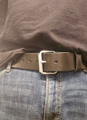 A customer wearing the wide, black Enforcer leather belt with a silver buckle and jeans.
