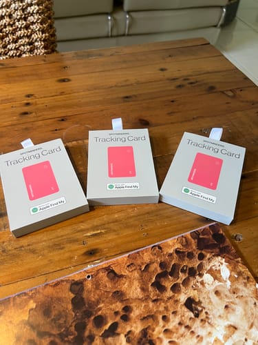 Customer's three boxes of the SPOTMINDERS. Tracking Card sitting on a wooden table.