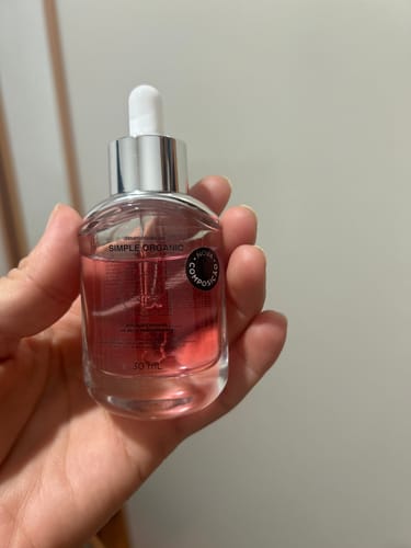Uma cliente segurando o frasco de vidro da Solução Gaba, mostrando o líquido rosa dentro.