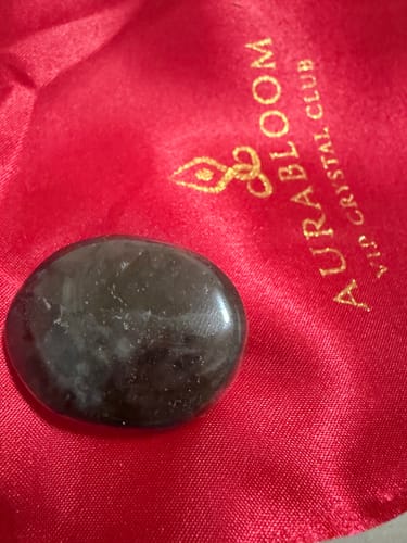 Customer's dark labradorite crystal from the VIP Crystal Club on its red pouch.