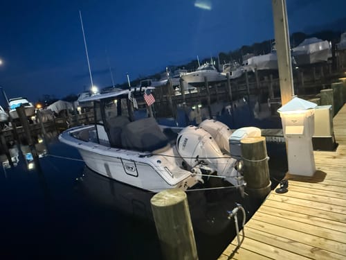 Customer's American Flag displayed on a white boat docked at a pier at night.