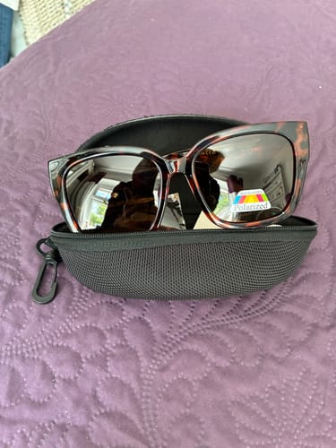 Customer's photo of the incorrect brown animal print sunglasses they received, shown inside a black case.