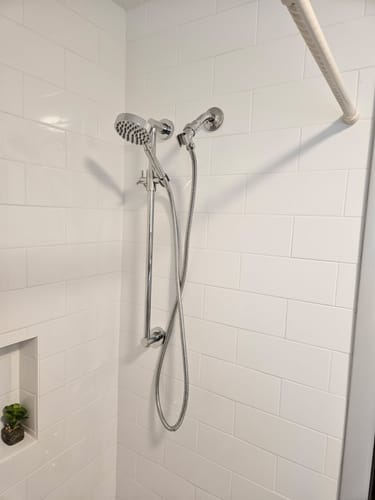 Customer's chrome Slide Bar with Shower Head Holder installed on a white tiled shower wall.