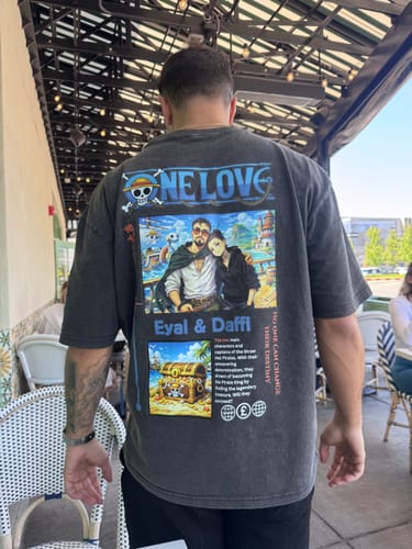 Customer showing the back of their grey custom ONE LOVE t-shirt, highlighting the large colorful print.