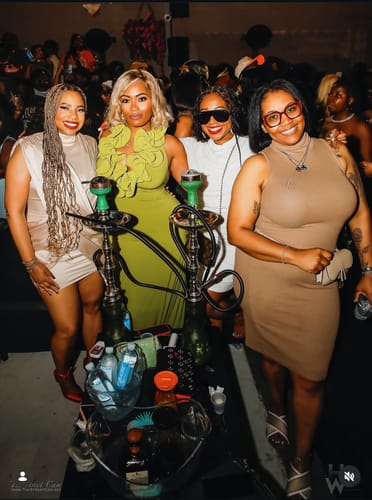 Reviewer posing in a group wearing the full-length, green Naked Ruffle Halter Maxi Dress at an event.