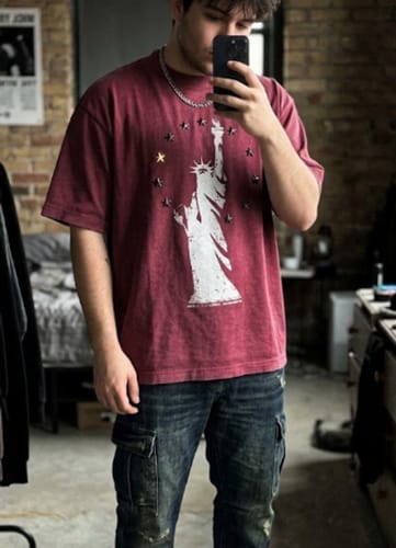 Reviewer wearing the oversized, vintage red Statue of Liberty T-shirt with star studs.
