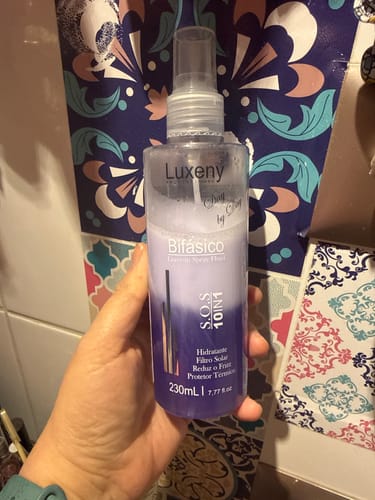 Cliente sosteniendo la botella del Spray Bifásico 10 en 1 en la mano.