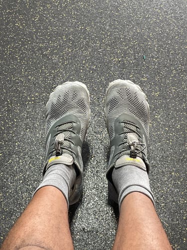 Customer's top-down view of the grey Smart Ⅰ - Barefoot Shoes being worn on a speckled gym floor.