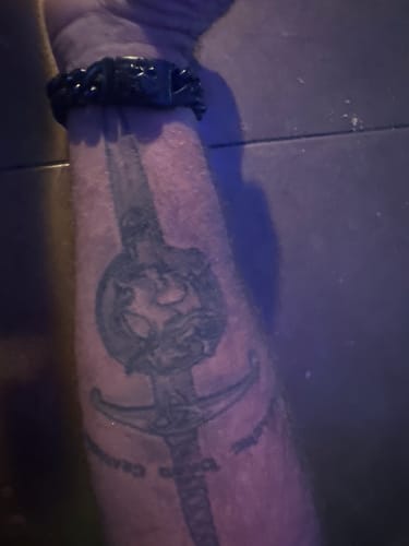 Customer wearing the black Vindicta Retribution Cuban Link Bracelet on their tattooed arm.