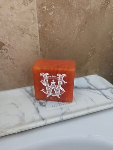 Customer's orange Oud Harmony soap bar with a white logo on a marble soap dish.