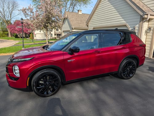 Customer's clean red SUV with glossy black tires parked in a driveway.