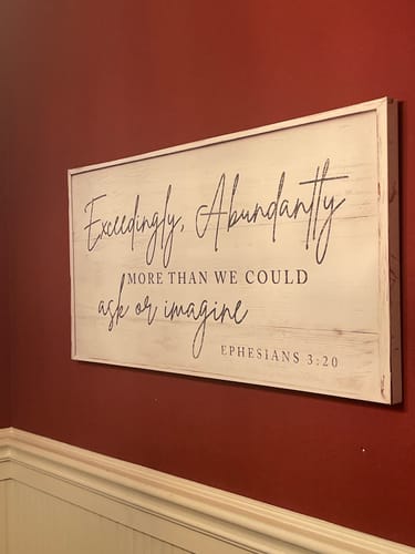 Customer's beautiful Faith Sign mounted at an angle on a dark red wall above white wainscoting.