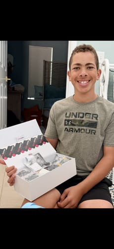 A smiling customer holds an open box displaying multiple animation figure kits.