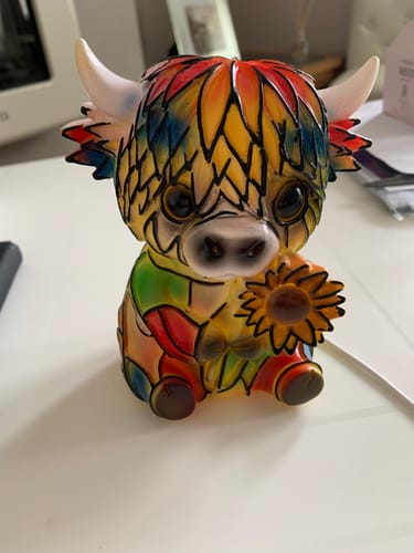 Customer's colorful Highland Cow LED Night Light sitting on a white desk, showing a glossy plastic-like finish.