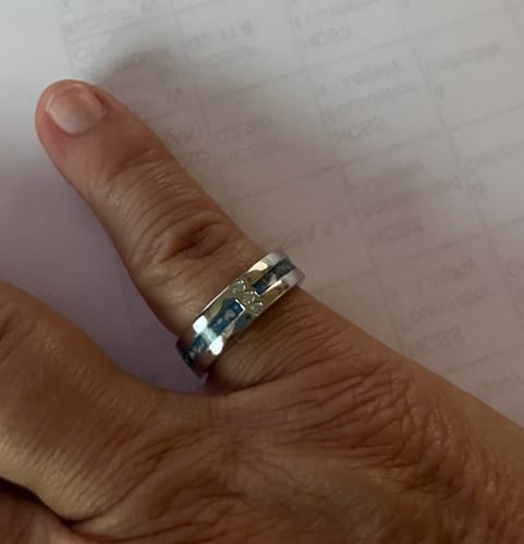 Close-up of the customer wearing the 3 Gem Ring on their finger, showing the blue infused band.