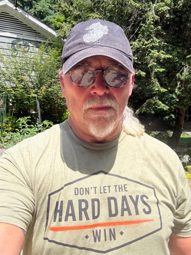 Reviewer wearing the green Hard Days Built t-shirt with the 'Don't Let The Hard Days Win' graphic outdoors.
