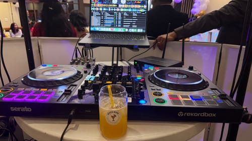 Reviewer's black Model-X 2.0 Stand holding a laptop above a DJ controller at an event.