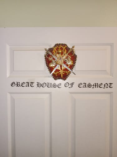 Reviewer's black Custom Wall Quote Vinyl Decal on a white door, reading 'Great House Of Easment' in a gothic font.