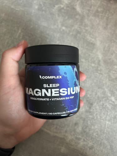 Customer holding a black jar of Complex Sleep Magnesium.