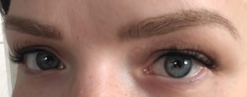 Rezensentin zeigt den eleganten Doll-Eye-Effekt der BAROQUE Wimpern an ihren kleinen Augen.