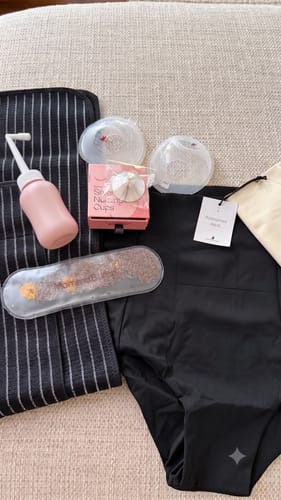 Customer's Postpartum Recovery Bundle items laid out, including briefs, a peri bottle, belly band, and nursing accessories.
