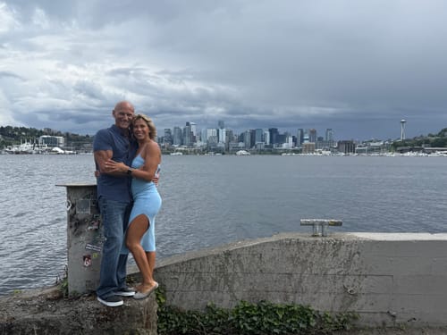 Reviewer wearing the light blue Sana Midi Dress with its side slit, posing with a person by the water.