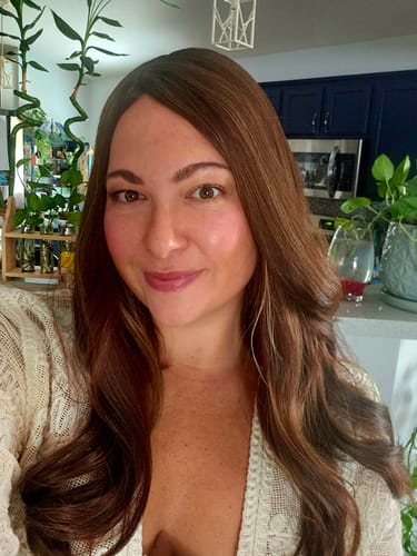 Customer taking a selfie showing the dimensional color and soft waves of the Cappuccino Blend Silk Topper.