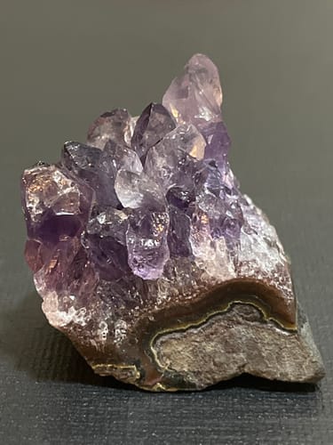 Customer's amethyst crystal cluster with purple points and a layered rock base, from the monthly subscription.