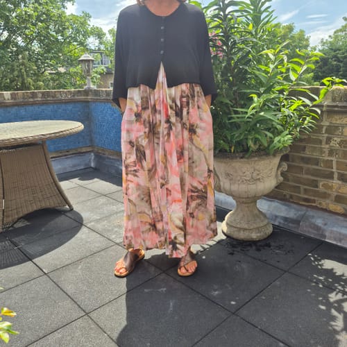 Customer on a patio showing the relaxed fit of the Rounded Black Linen Cardigan over a dress.