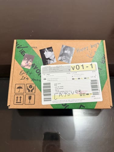 Customer's shipping box for the BTS V - LAYOVER album, shown as it arrived decorated with photos.