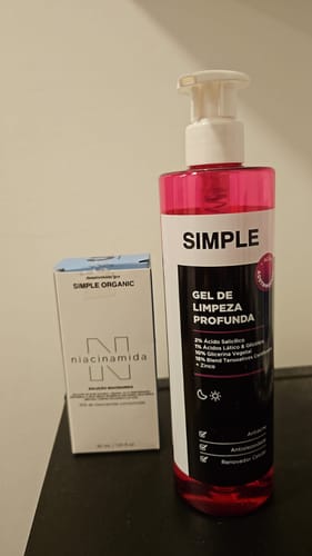 Foto do cliente com o Meu Primeiro Kit, mostrando o gel de limpeza profunda e a caixa de niacinamida.