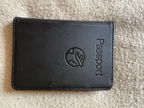 Customer's black leather Trackable Passport Cover showing the embossed logo and vertical 'Passport' text.