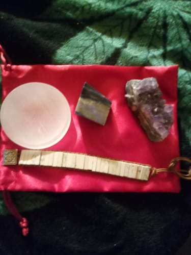 Customer's AuraBloom Subscription Box items: Amethyst, Sodalite, Selenite plate, and a Howlite bracelet on a red pouch.