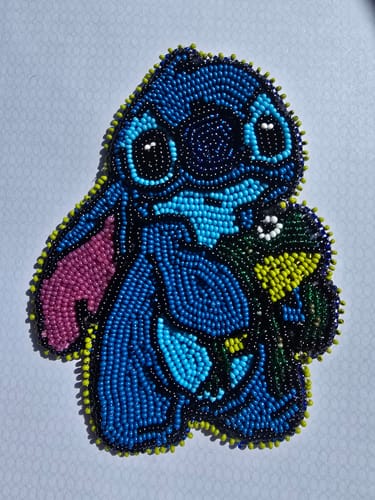 Customer's original beadwork of a blue character, which was used to create their custom stickers.
