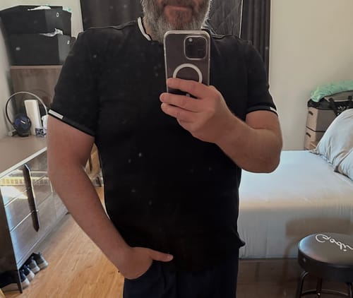 Client portant le T-shirt Harden noir, montrant les détails rayés du col et des manches.