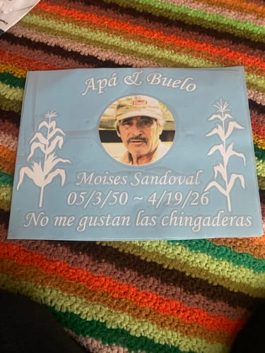 Customer's custom vinyl memorial decal in light blue with a photo, Spanish text, and corn stalk graphics.