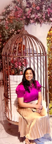 Reviewer wearing the bright magenta Forever In Bloom Blouse while seated.